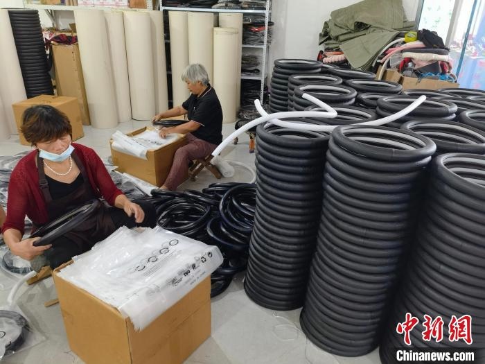 圖為村民在汽車飾品企業(yè)生產(chǎn)車間中工作。　呂子豪 攝