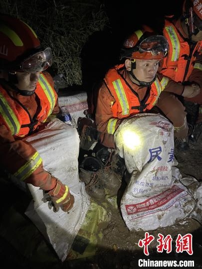 短暫修整期間，消防員脫掉鞋襪，用編織袋套住腿腳保暖。　閆旭輝 攝