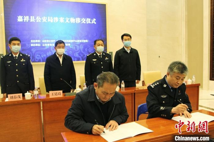 山東博物館館長鄭同修和嘉祥縣人民政府副縣長、公安局局長趙健簽署移交協(xié)議。　趙曉 攝
