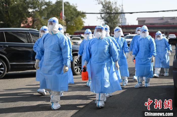 圖為醫(yī)務(wù)人員在封閉小區(qū)做防控工作?！⑽娜A 攝