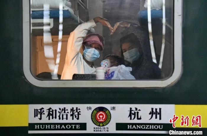 圖為登上轉(zhuǎn)運火車的游客向額濟納比心。　王磊 攝