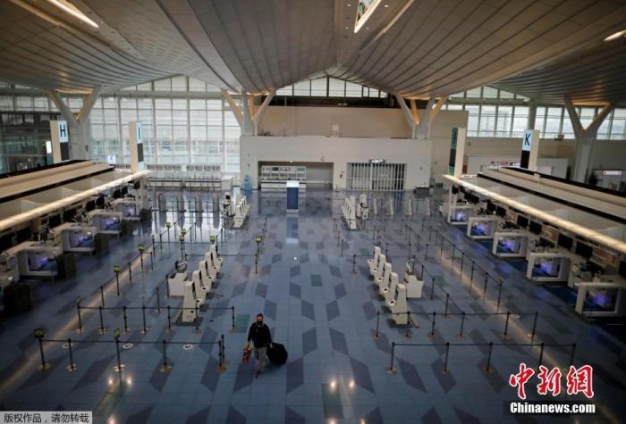 資料圖：日本東京，東京國際機場，一名乘客在國際航班航站樓的登機區(qū)。