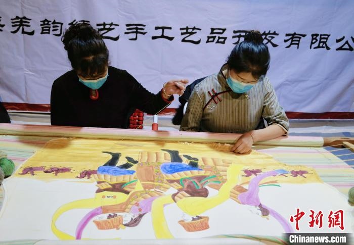 圖為皮繡藝人在市集上“秀”指尖技藝?！●R銘言 攝