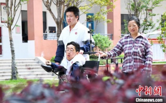 碰上天氣好，朱金祥就會利用休息時間，和鐘華強母親將其推出來賞賞花，曬曬太陽，呼吸一下外面的新鮮空氣。 卓忠偉 攝