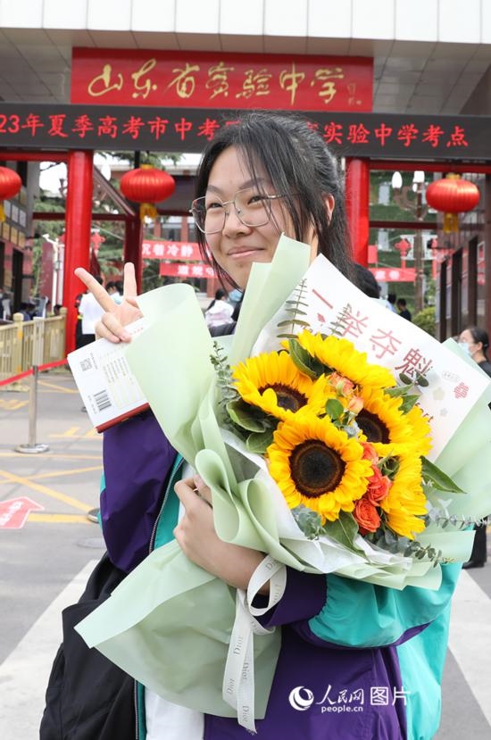 6月7日高考首日，山東67萬考生走進(jìn)考場，拼搏逐夢。在山東省實驗中學(xué)考點，考生進(jìn)考場前手捧向日葵花拍照留念，寓意“一舉奪魁”。人民網(wǎng)記者 劉祺攝