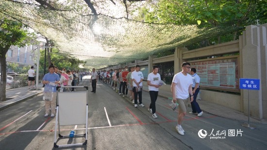 6月7日，烏魯木齊市第七十中學(xué)門口，考生們有序進(jìn)入考場。人民網(wǎng) 李欣洋攝