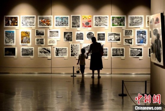 圖為家長(zhǎng)帶著孩子參觀展覽。呂明 攝