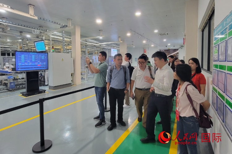 廣汽埃安工作人員向外媒記者進行介紹。人民網(wǎng) 寧玉瑛攝