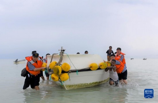 7月21日，中國海軍“和平方舟”號(hào)醫(yī)院船醫(yī)護(hù)人員涉水登島，前往基里巴斯一診療點(diǎn)。新華社記者 黎云 攝