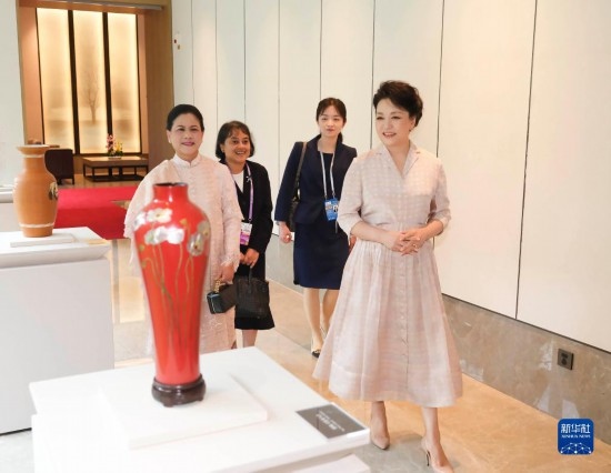 7月27日下午，國家主席習(xí)近平夫人彭麗媛在四川成都會見陪同印度尼西亞總統(tǒng)佐科來華出席第31屆世界大學(xué)生夏季運動會開幕式并訪華的總統(tǒng)夫人伊莉亞娜。這是彭麗媛和伊莉亞娜欣賞成都特色非遺工藝品。新華社記者 丁林 攝