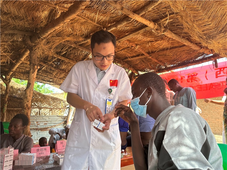 圖為南昌大學(xué)第一附屬醫(yī)院病理科主治醫(yī)師張振東為村民解說(shuō)藥品使用方法。中國(guó)駐乍得醫(yī)療隊(duì)供圖