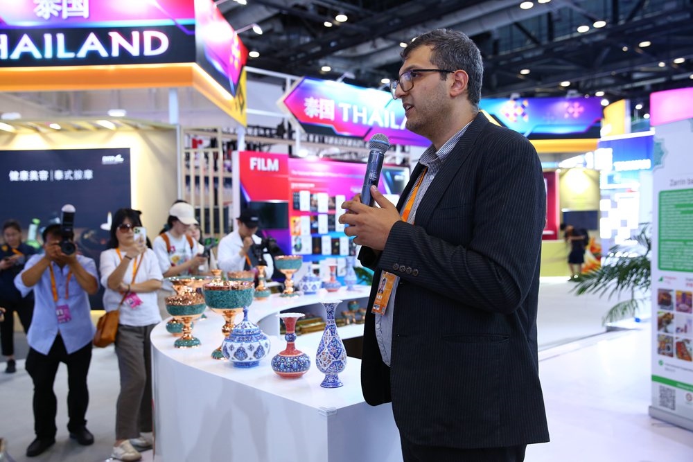 9月1日，參展商在國家會議中心向媒體記者介紹展臺信息。新華社記者 孫瑋彤 攝