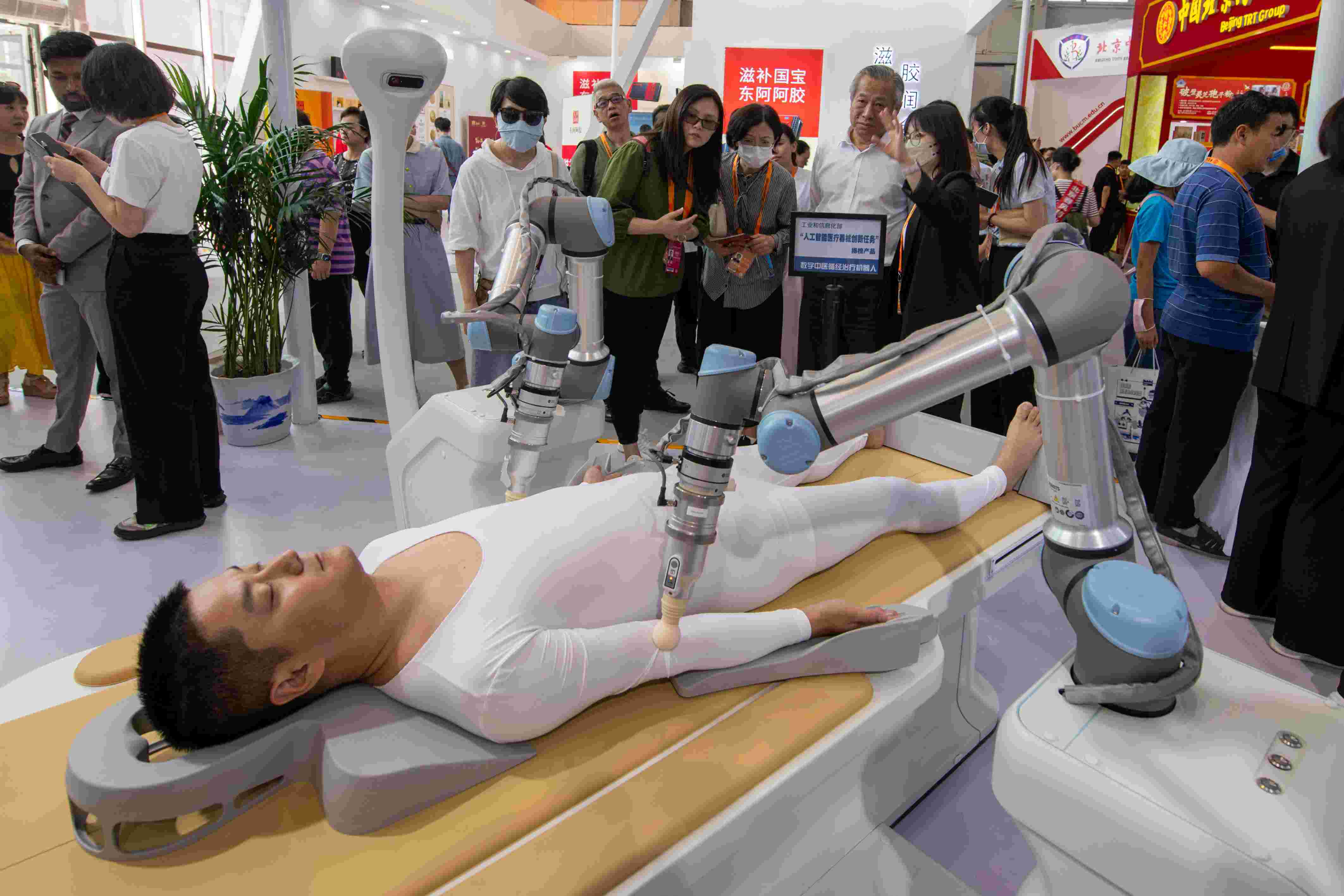 在位于首鋼園的健康衛(wèi)生服務(wù)展區(qū)，觀眾正在參觀數(shù)字中醫(yī)循經(jīng)治療機(jī)器人。人民網(wǎng)記者 翁奇羽攝