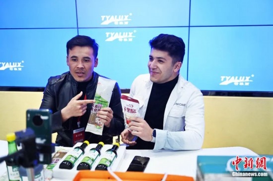 2023年3月，甘肅省慶陽市環(huán)縣電商創(chuàng)業(yè)孵化基地內(nèi)，來自蘭州文理學(xué)院的塔吉克斯坦留學(xué)生正在協(xié)助主播直播帶貨當(dāng)?shù)剞r(nóng)特產(chǎn)品。李亞龍 攝