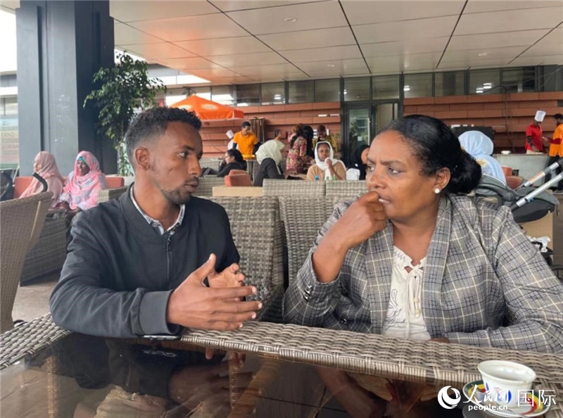 約漢斯（圖左）與德貝拉在友誼廣場咖啡廳交談。人民網(wǎng)記者 趙艷紅攝