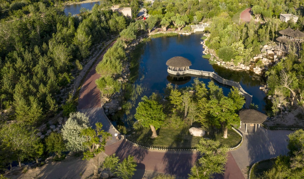 坐落在寧夏銀川市賀蘭山腳下的賀蘭山運(yùn)動休閑公園（2021年5月27日攝，無人機(jī)照片）。這里曾是一片砂石采礦塌陷區(qū)，當(dāng)?shù)赝ㄟ^植被景觀再造、水系建設(shè)、現(xiàn)代管網(wǎng)鋪建等手段，重新利用廢石、廢坑及各類廢棄建筑材料，把這里變成一座免費(fèi)開放的主題公園。新華社記者 馮開華 攝