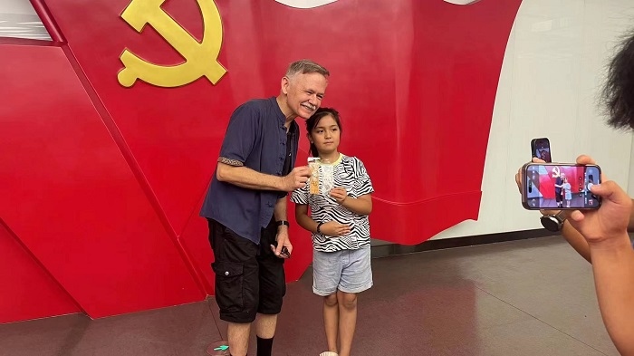 潘維廉和志愿講解員紀念合影。主辦方供圖