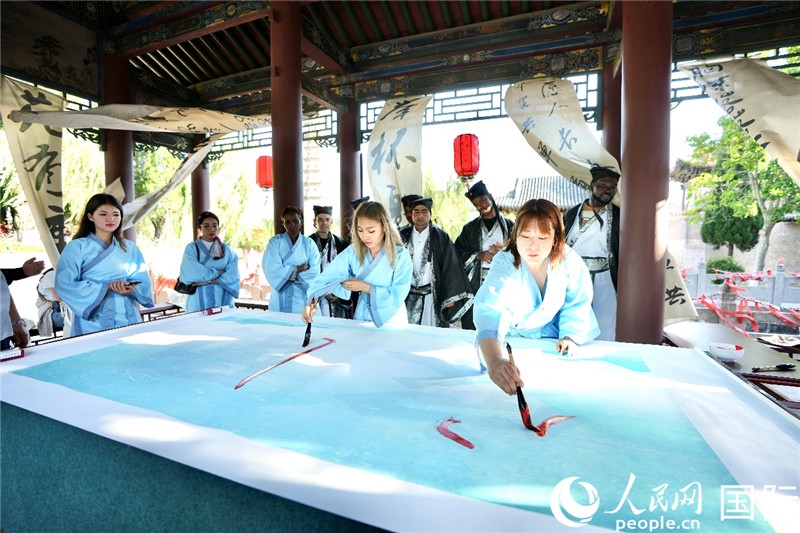 選手們提筆書寫“家園”二字。人民網(wǎng) 盧鵬宇攝