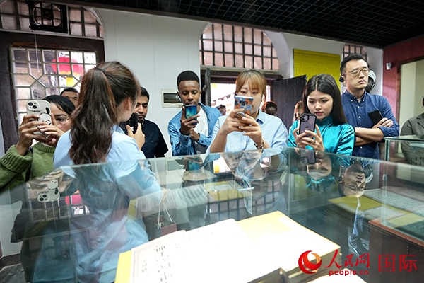 選手們認(rèn)真聆聽導(dǎo)游講解。人民網(wǎng) 盧鵬宇攝