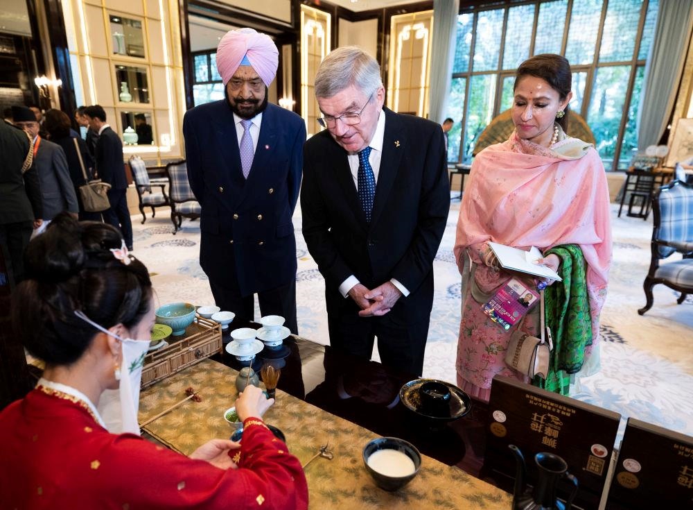 △歡迎宴會前，亞奧理事會代理主席辛格和夫人維尼塔、國際奧委會主席巴赫欣賞非遺展示。