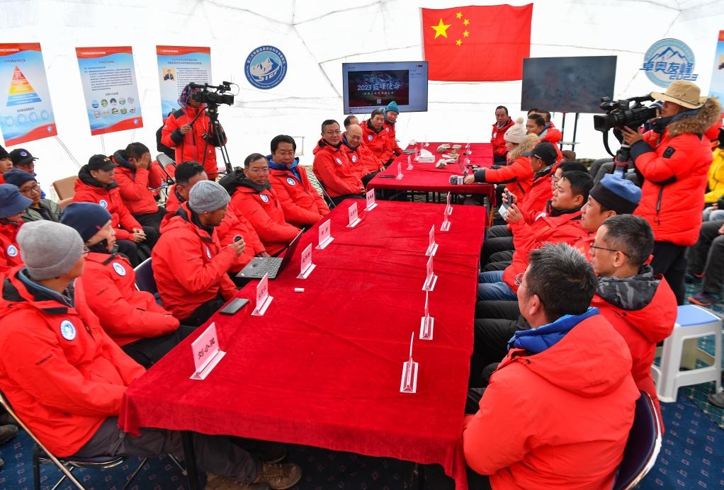 海拔4950米的卓奧友峰科考大本營，科考隊員趙華標(biāo)（手拿麥克風(fēng)看電腦者）在宣讀剛剛接收到的頂峰氣象觀測數(shù)據(jù)，這標(biāo)志著峰頂自動氣象站架設(shè)成功，成功傳回觀測數(shù)據(jù)（10月1日攝）。新華社記者晉美多吉 攝