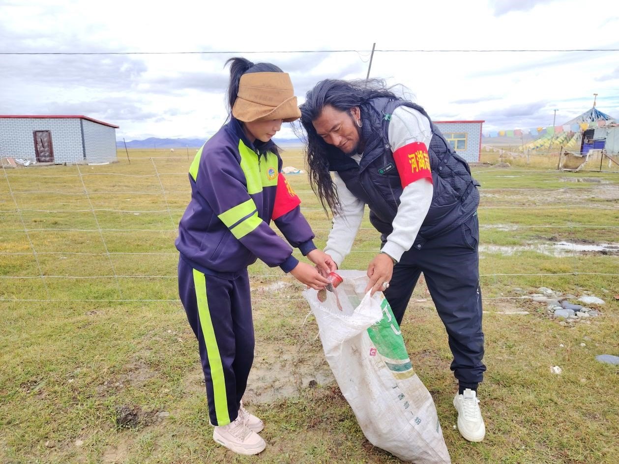 玉樹州稱多縣珍秦鎮(zhèn)河湖志愿者才培和他女兒更求拉毛在清掃垃圾。受訪者供圖