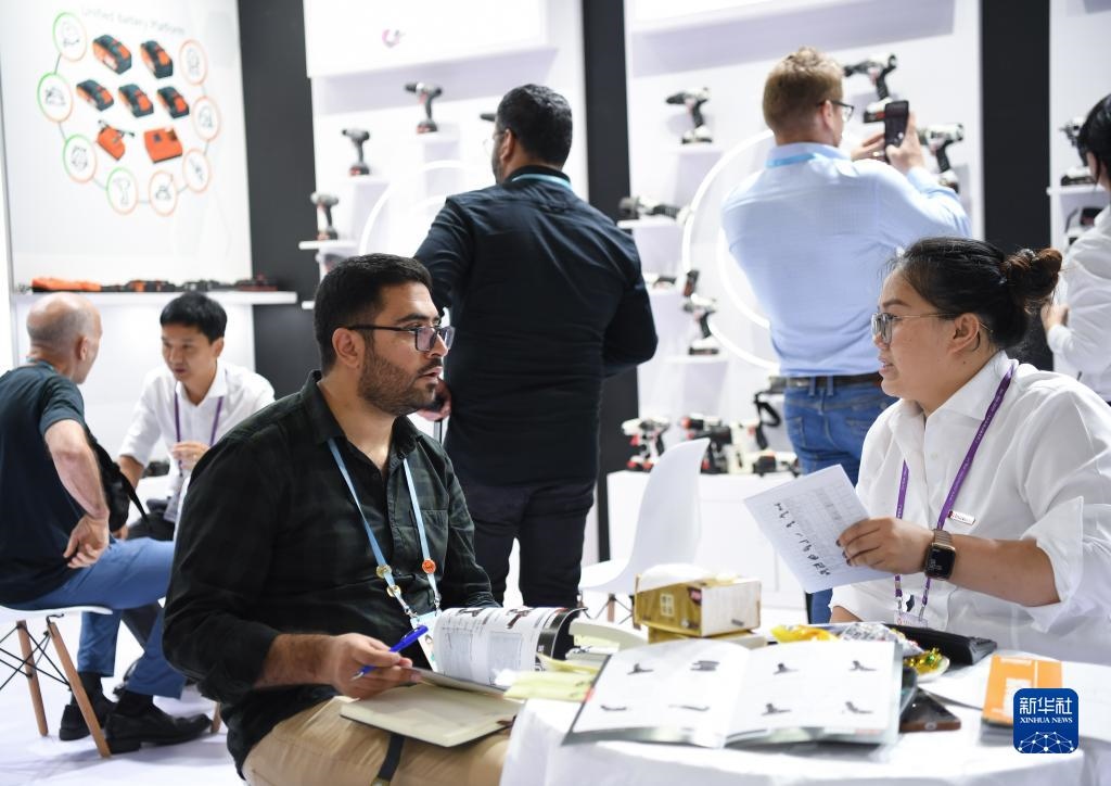 10月15日，在一家電動(dòng)工具展臺(tái)，外國采購商在洽談業(yè)務(wù)。新華社記者 鄧華 攝