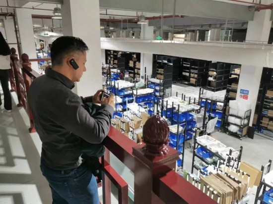 2023“一帶一路”媒體合作論壇聯(lián)合采訪團(tuán)團(tuán)員在仁和醫(yī)藥物流園拍攝記錄轉(zhuǎn)運流程。（本報記者 黃超攝）