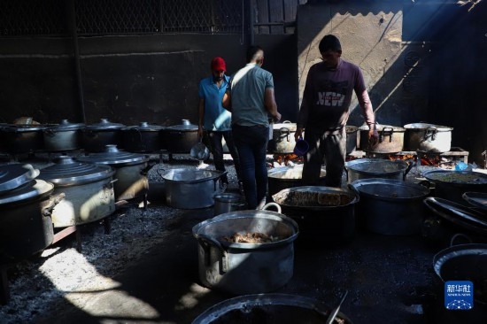 11月3日，在加沙地帶南部城市拉法，人們?cè)诿簹庵袛嗪笥貌窕鹱鲲?。新華社發(fā)（里澤克·阿卜杜勒賈瓦德攝）