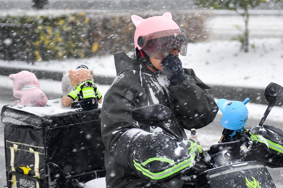 11月6日，在長(zhǎng)春市街頭，一名外賣員在雪中騎行。新華社記者 許暢 攝