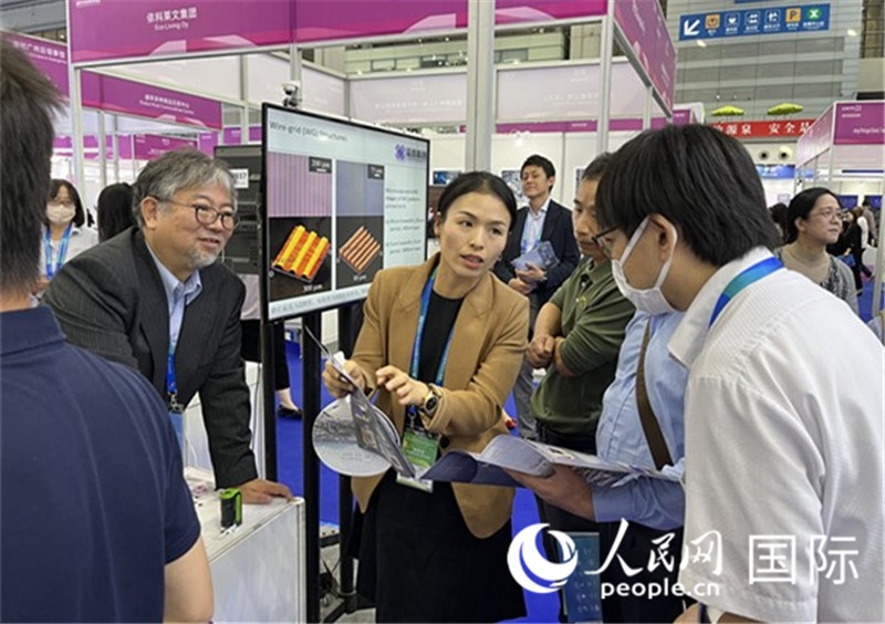 工作人員向參觀者介紹超級噴墨技術(shù)。(人民網(wǎng)記者 陳思攝)