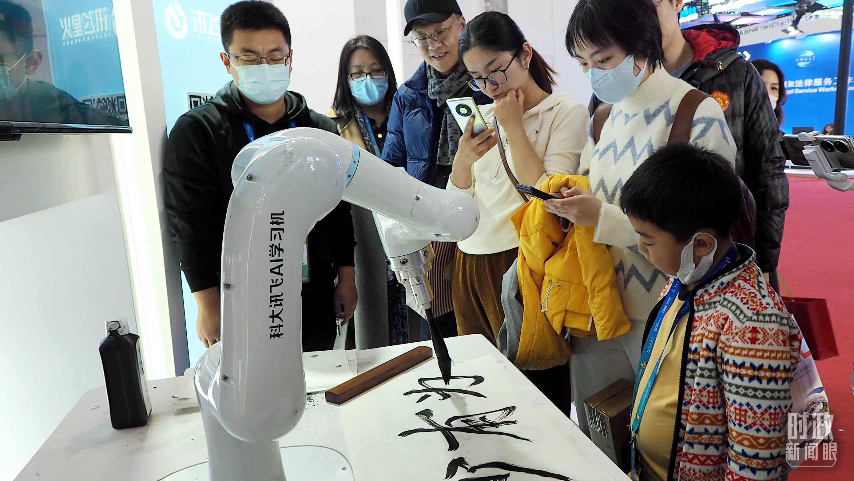 △觀眾在首屆鏈博會上體驗AI書法機器人。
