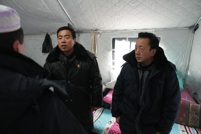 2023年12月22日，積石山縣大河家鎮(zhèn)大河村黨支部書記馬成忠（右二）在帳篷里和受災群眾交流。新華社記者 陳斌 攝