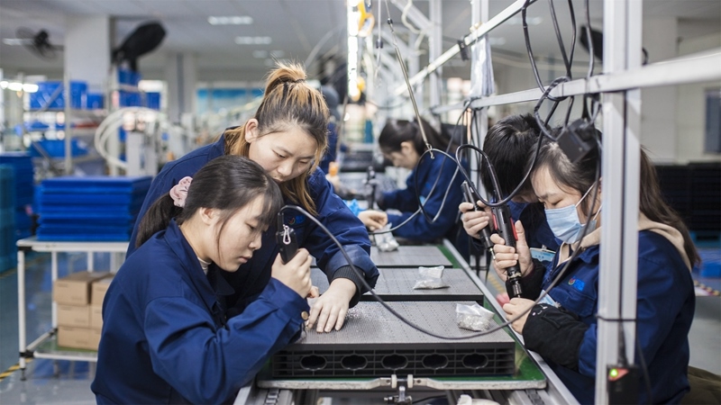 在新亞勝光電的產(chǎn)品線上，工人正進(jìn)行產(chǎn)品組建和安裝布線。受訪者供圖