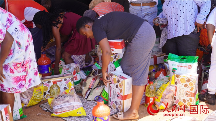 當(dāng)?shù)厣鐓^(qū)家庭領(lǐng)取物資。人民網(wǎng) 張茜攝