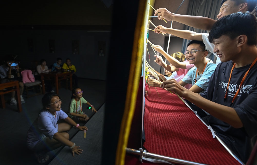 2023年8月8日，進(jìn)行暑期研學(xué)的學(xué)生在位于陜西省西安市的中國秦腔藝術(shù)博物館體驗皮影戲演出。新華社記者 鄒競一 攝