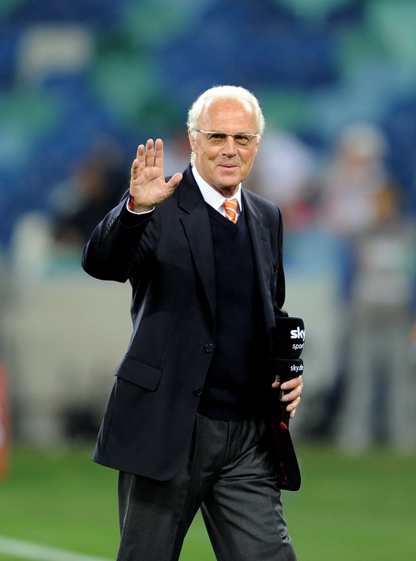 這是2010年7月7日，在南非德班舉行的2010年足球世界杯德國隊對陣西班牙隊的半決賽前，貝肯鮑爾接受電視臺采訪時和友人打招呼。新華社記者 王毓國 攝