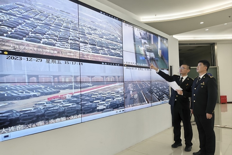 海關(guān)關(guān)員視頻巡查出口汽車場地。李進(jìn)攝