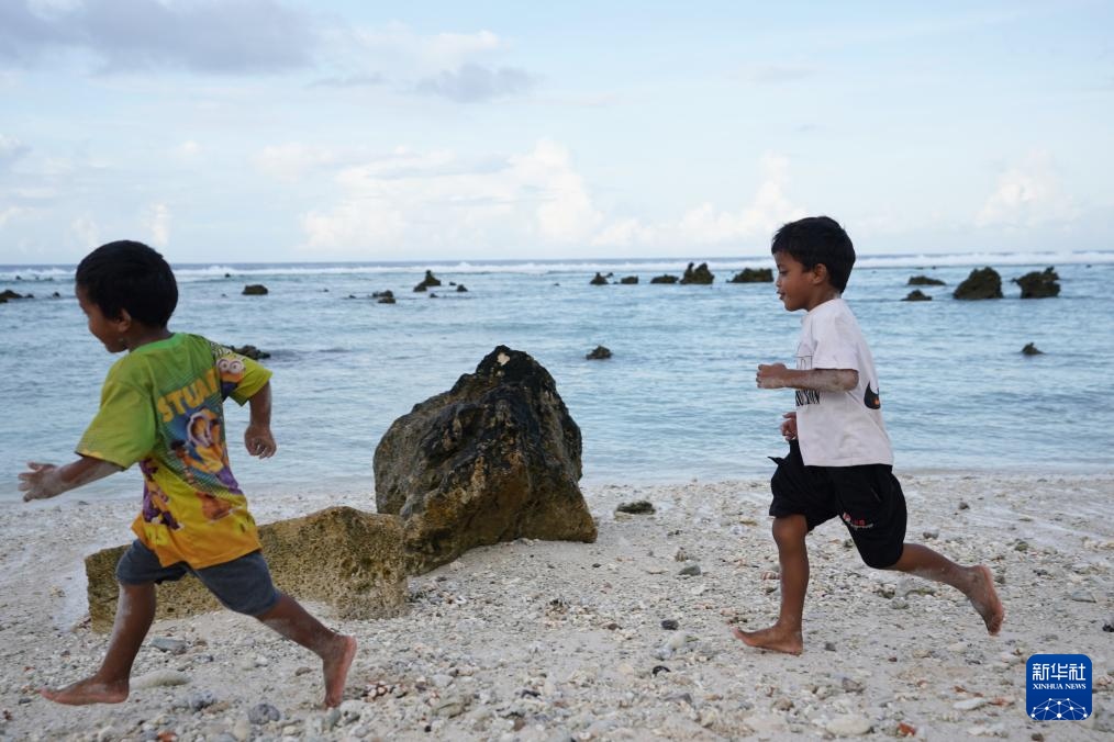 1月20日，兒童在瑙魯海邊嬉戲。新華社記者 王申 攝