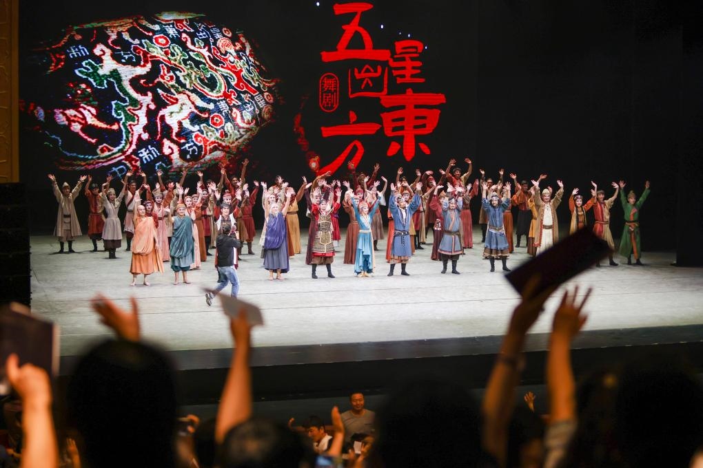 2023年7月31日，新疆和田地區(qū)新玉歌舞團(tuán)在烏魯木齊京劇院演出舞劇《五星出東方》后和觀眾互相揮手致意。這場(chǎng)演出是第六屆中國新疆國際民族舞蹈節(jié)的參演劇目之一，曾榮獲國家“文華獎(jiǎng)”等。新華社記者 郝昭 攝