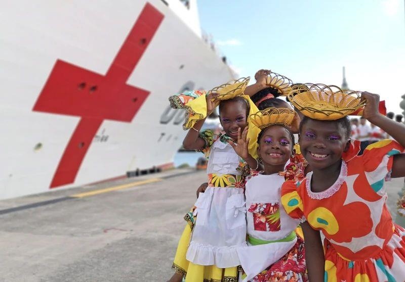 2018年10月，在安提瓜和巴布達(dá)首都圣約翰，當(dāng)?shù)匦∨笥焉泶﹤鹘y(tǒng)服裝歡迎中國海軍“和平方舟”醫(yī)院船首次到訪。