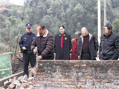  圖③：庭審結(jié)束后，在法官的見(jiàn)證下，陳某在院壩邊重新開(kāi)鑿一條通道。