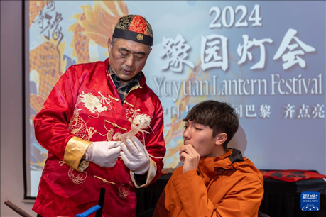 1月28日，在上海豫園舉行的民俗活動上，美國馬斯卡廷中學學生在非遺傳承人的指導下吹糖偶。 新華社記者 王翔 攝