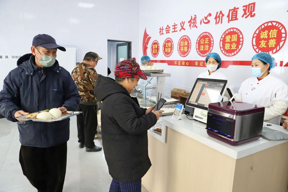 △2024年2月1日，市民在河北涿州市雙塔街道永濟(jì)秀園小區(qū)便民食堂內(nèi)購買午餐。