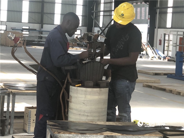 經(jīng)貿(mào)合作區(qū)廠房內(nèi)，當?shù)毓と苏诰o張作業(yè)。人民網(wǎng)記者 黃培昭攝