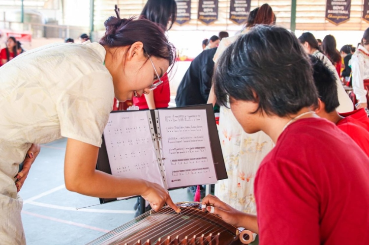 志愿者教師指導(dǎo)學(xué)生彈奏古箏?；顒?dòng)主辦方供圖