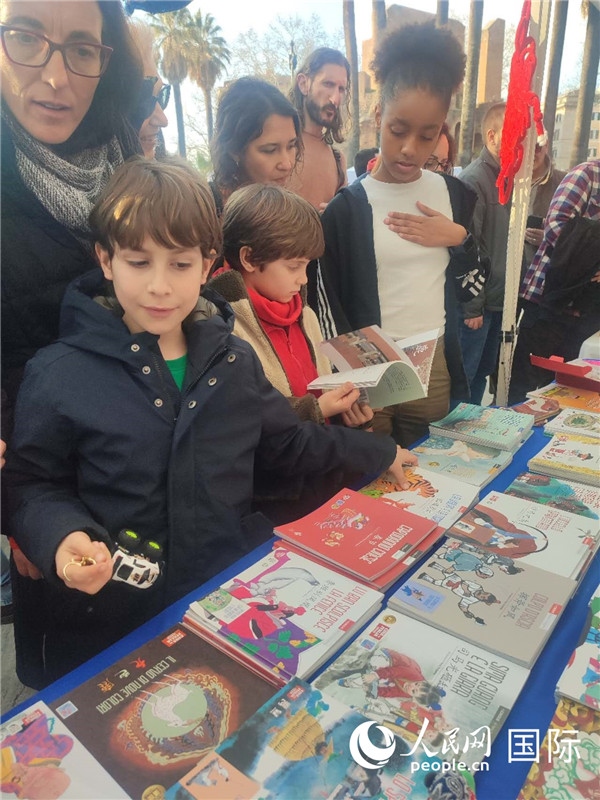 印刷精美的中國傳統(tǒng)文化叢書吸引了小游客的注意。人民網(wǎng)記者鄭彬攝