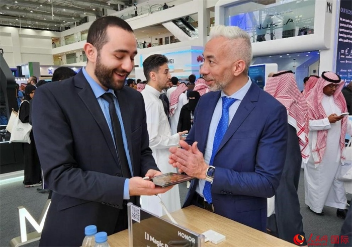 兩名觀眾在榮耀手機(jī)展臺(tái)前交流。人民網(wǎng)記者 管克江攝