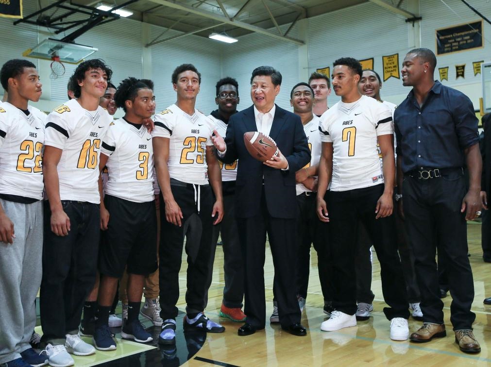 2015年9月23日，國家主席習(xí)近平參觀美國塔科馬市林肯中學(xué)。這是習(xí)近平在學(xué)校體育館，同上橄欖球訓(xùn)練課的學(xué)生們親切交談。新華社記者 蘭紅光 攝