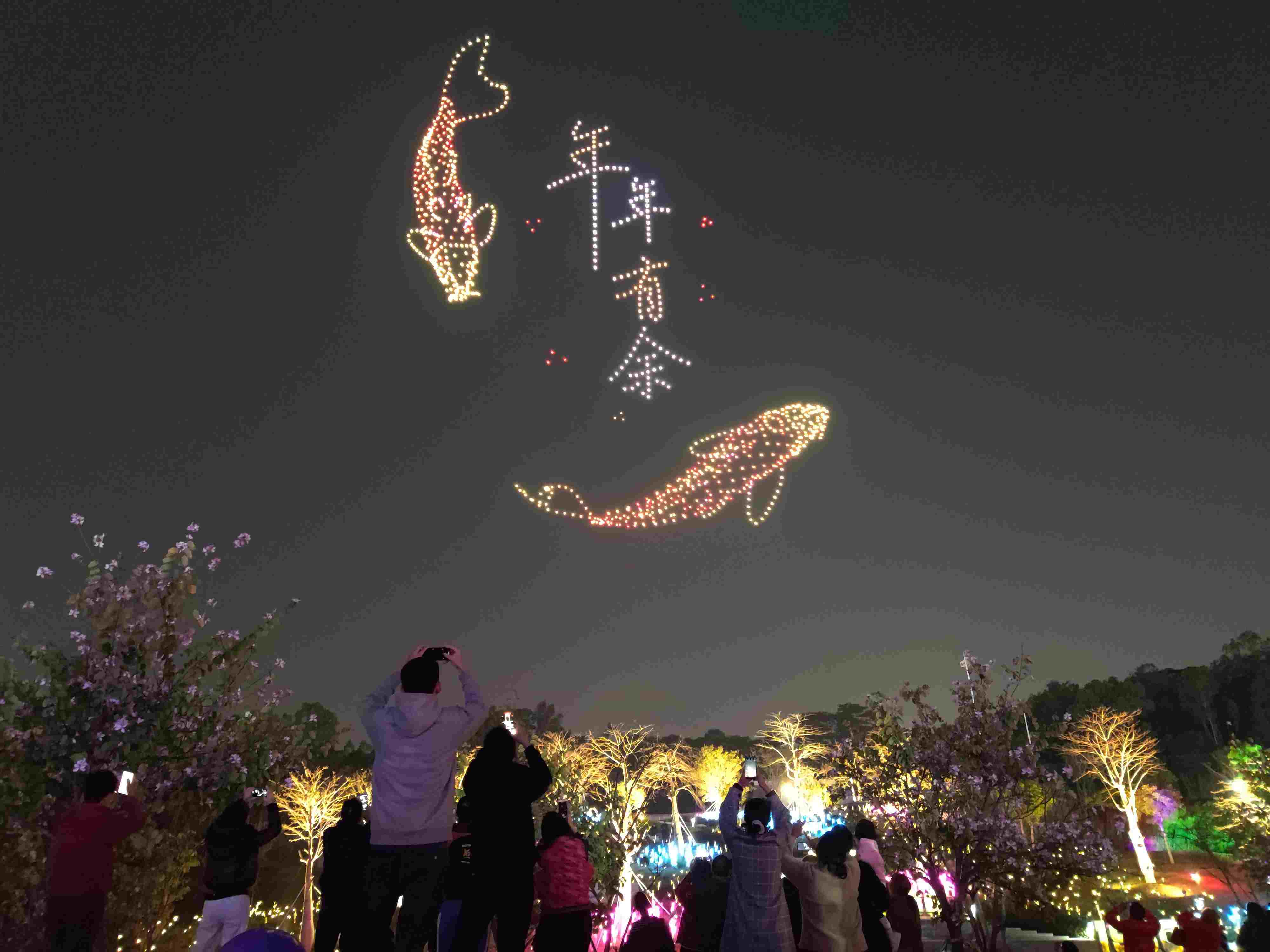 △ 2024年2月10日，深圳北站中心公園，春節(jié)主題無人機(jī)燈光秀引來眾多游客駐足觀看。